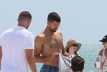 Novak Djokovic shirtless on a beach