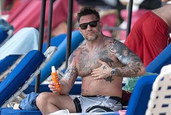 Tom Hardy shirtless on a beach